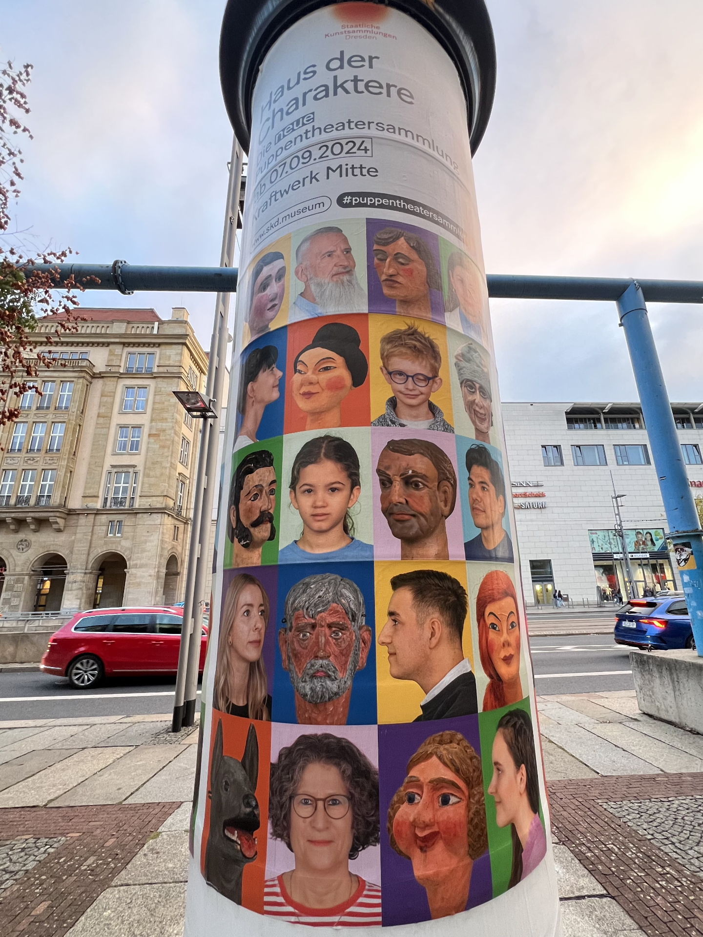 Litfaßsäule mit Kampagnenmotiv „Haus der Charaktere — Die neue Puppentheatersammlung" der Staatlichen Kunstsammlungen Dresden